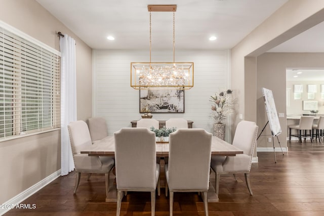 dining space with dark wood-type flooring and an inviting chandelier