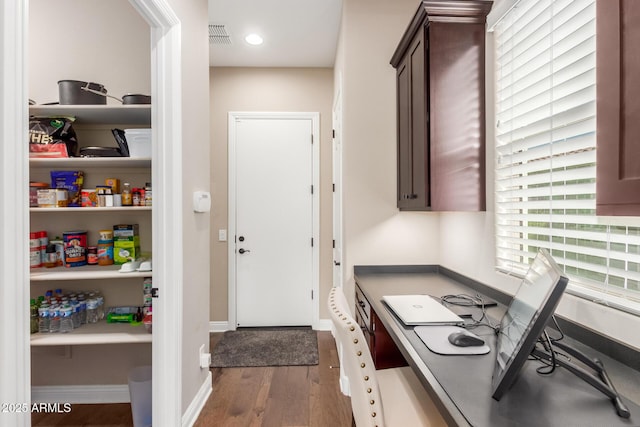 kitchen featuring dark wood-type flooring and dark brown cabinets