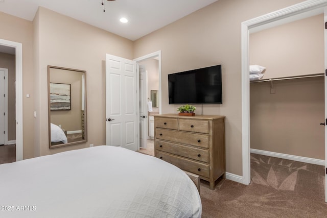 carpeted bedroom featuring a walk in closet and a closet