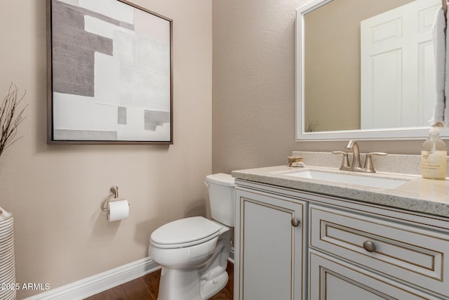 bathroom featuring vanity, hardwood / wood-style floors, and toilet