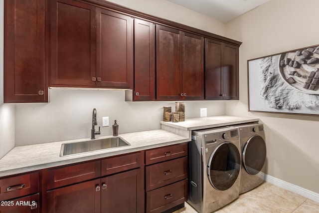 laundry room featuring sink, light tile patterned floors, washing machine and dryer, and cabinets