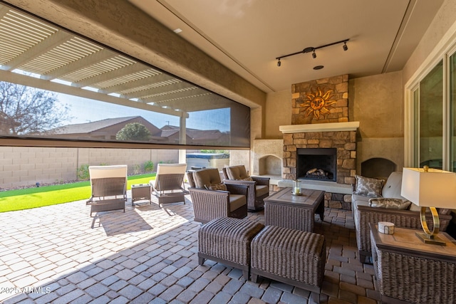 view of patio with an outdoor living space with a fireplace