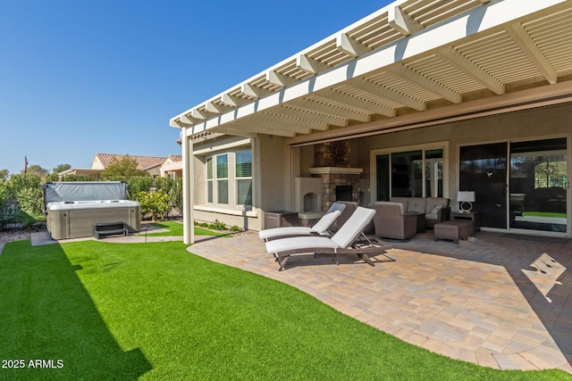 rear view of property with a patio area, a hot tub, a lawn, a pergola, and an outdoor living space with a fireplace