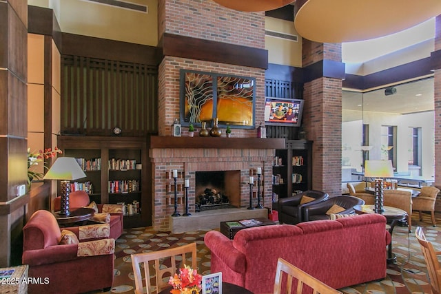 living room with a brick fireplace and a high ceiling