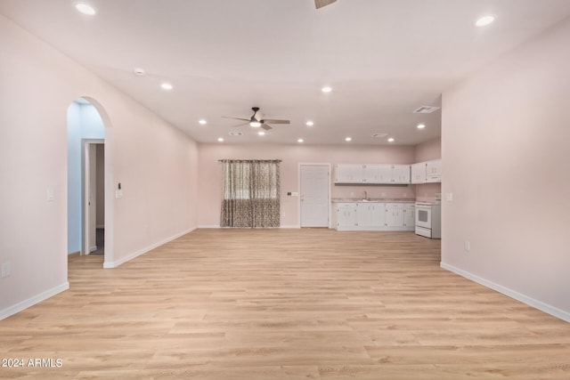 unfurnished living room featuring ceiling fan, light wood-type flooring, and sink