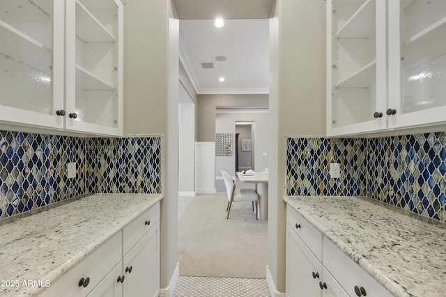 kitchen with crown molding, light stone countertops, decorative backsplash, and white cabinets