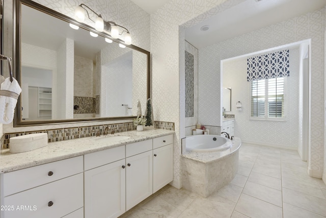 bathroom featuring vanity and tiled bath