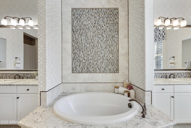 bathroom featuring vanity and tiled bath