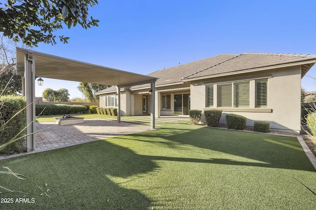 rear view of property with a yard and a patio area