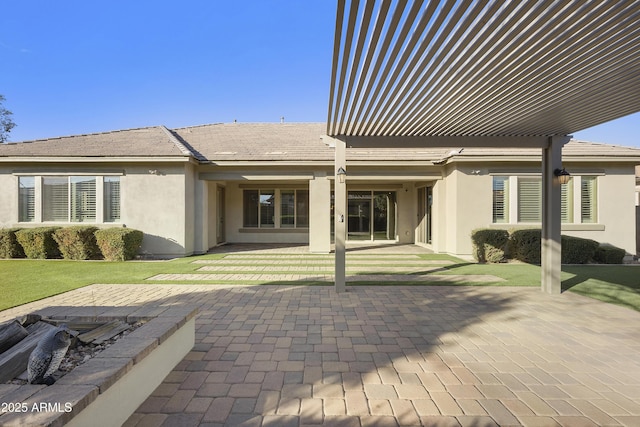 rear view of house featuring a yard, a pergola, and a patio