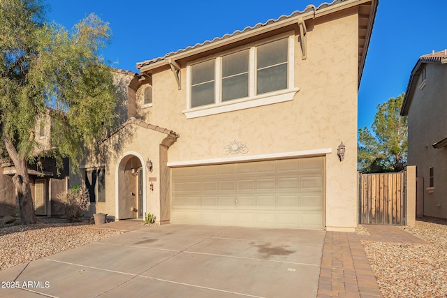 9009 S 57th Dr, Laveen, AZ 85339 - mediterranean / spanish-style house featuring driveway, stucco siding, an attached garage, and a tiled roof