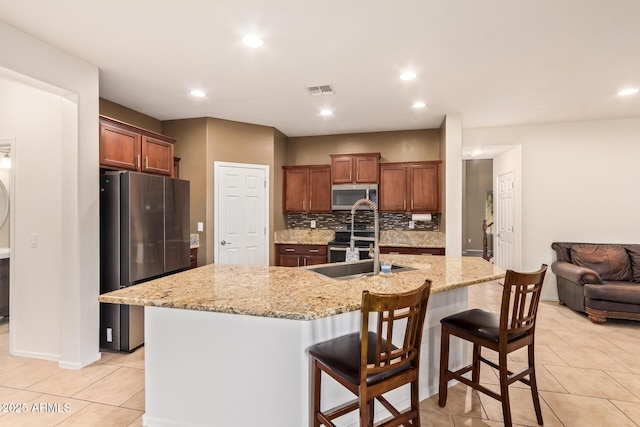 9009 S 57th Dr, Laveen, AZ 85339 - kitchen featuring light stone counters, a sink, tasteful backsplash, stainless steel appliances, and recessed lighting