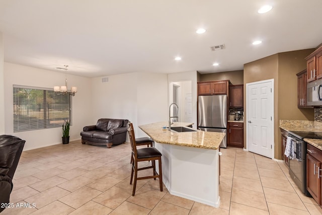 9009 S 57th Dr, Laveen, AZ 85339 - kitchen with a sink, a breakfast bar area, appliances with stainless steel finishes, open floor plan, and visible vents