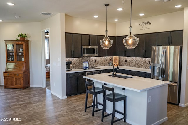 kitchen with visible vents, a sink, light countertops, appliances with stainless steel finishes, and backsplash