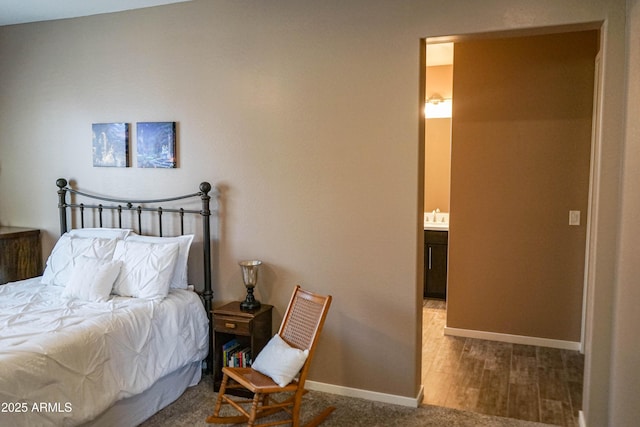 bedroom with wood finished floors and baseboards