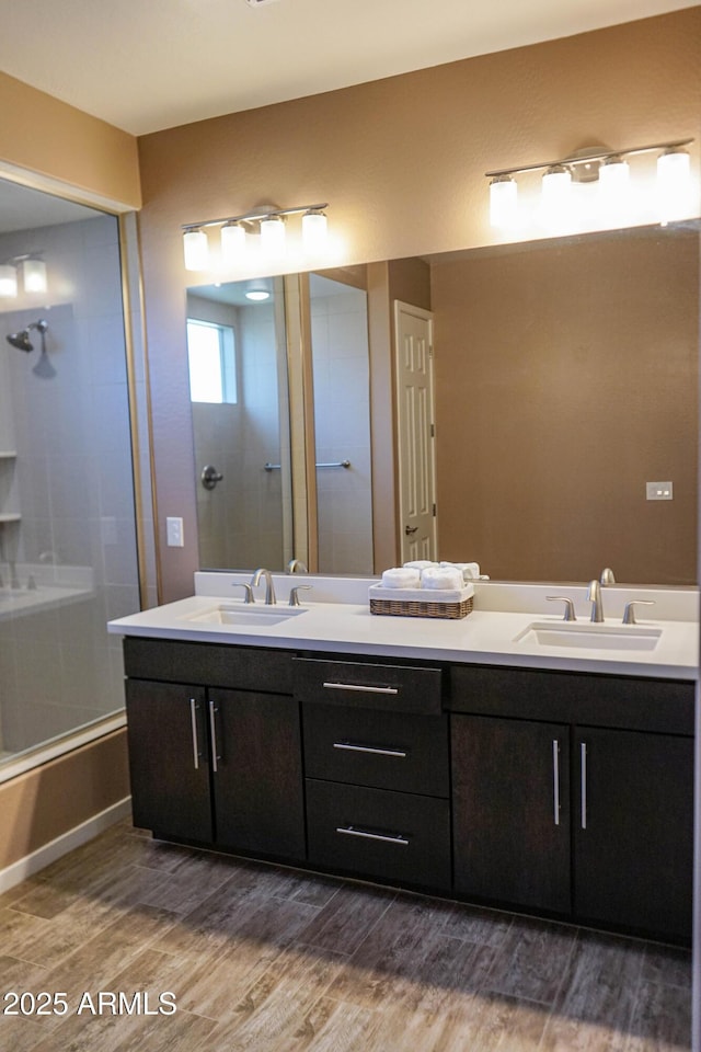 bathroom with double vanity, wood finished floors, and a sink