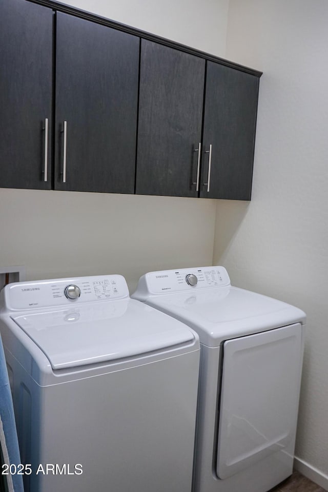 washroom with cabinet space and washing machine and dryer