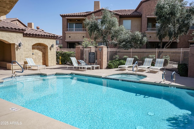 pool featuring a patio, a community hot tub, and fence