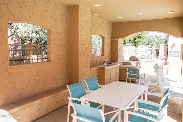 view of patio / terrace featuring a sink, outdoor dining area, and area for grilling