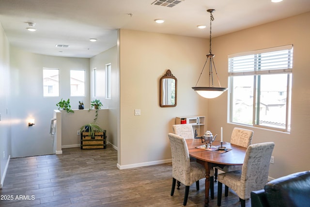 dining room featuring visible vents, baseboards, and wood finished floors