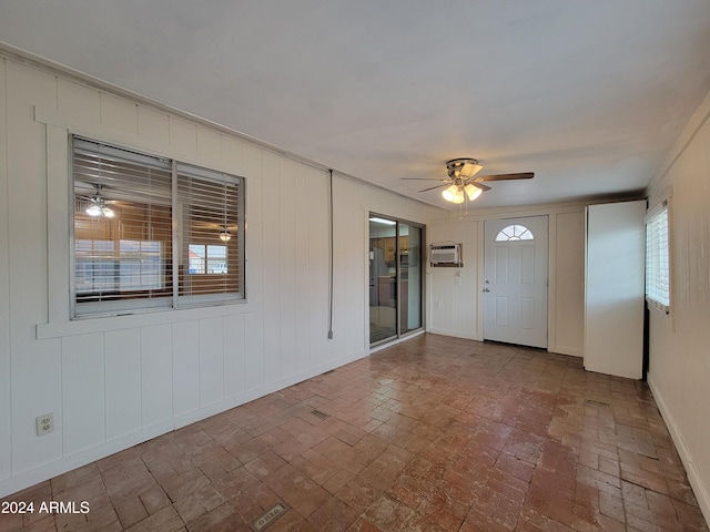 foyer featuring ceiling fan, a healthy amount of sunlight, and an AC wall unit