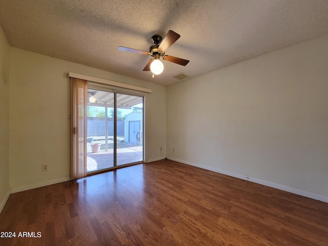 spare room with a textured ceiling, dark hardwood / wood-style floors, and ceiling fan