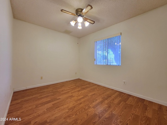 unfurnished room featuring a textured ceiling, hardwood / wood-style flooring, and ceiling fan