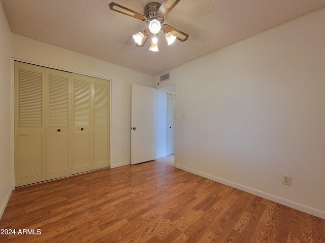 unfurnished bedroom featuring ceiling fan, a textured ceiling, and light hardwood / wood-style flooring