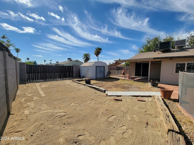 view of yard featuring a patio area, cooling unit, and a storage shed