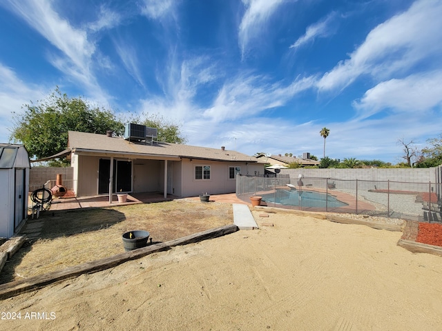 back of property with a fenced in pool, a patio area, and central AC unit