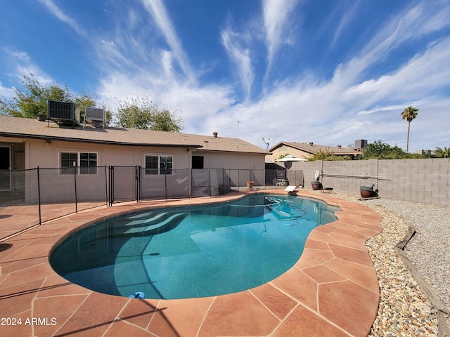 view of pool with a patio area and cooling unit