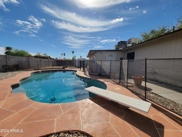 view of pool featuring a diving board and a patio