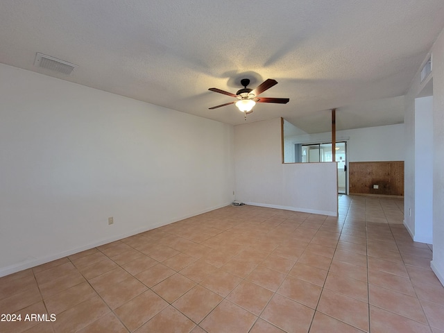 tiled empty room with a textured ceiling and ceiling fan