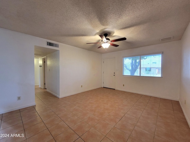 tiled spare room with ceiling fan and a textured ceiling