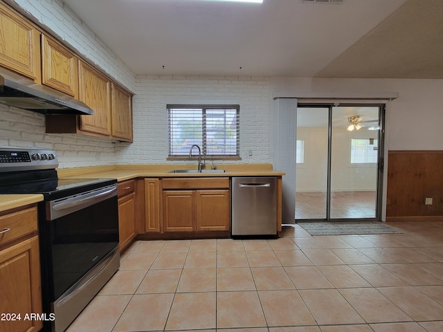 kitchen featuring stainless steel appliances, sink, light tile patterned floors, ceiling fan, and extractor fan