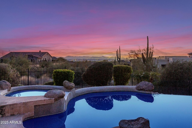 view of pool at dusk