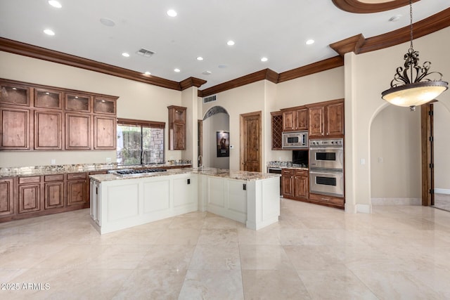 kitchen with stainless steel appliances, a kitchen island, and light stone countertops