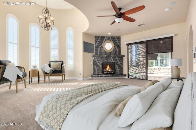 living room with ceiling fan with notable chandelier, carpet, a wealth of natural light, and a fireplace