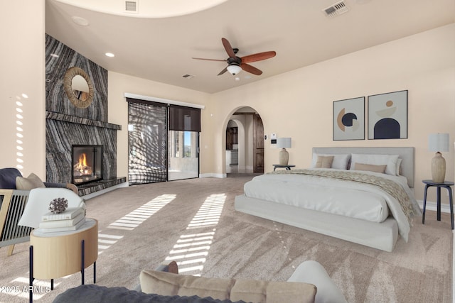 bedroom featuring a large fireplace, carpet flooring, and access to outside