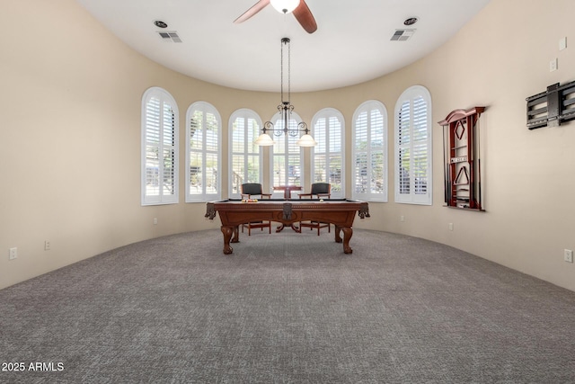 miscellaneous room featuring ceiling fan with notable chandelier and carpet floors