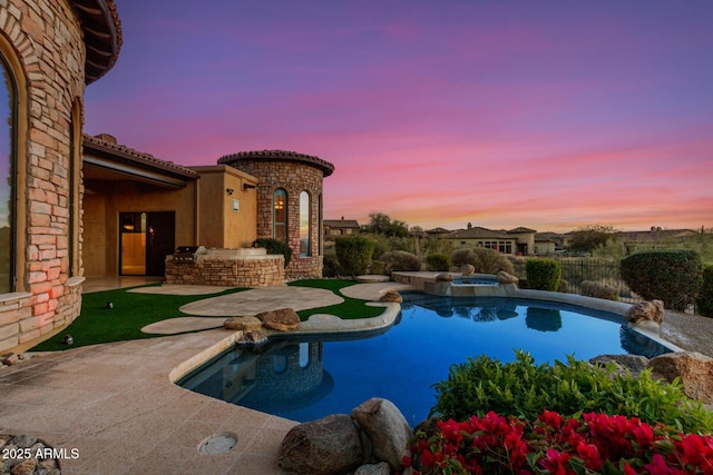 pool at dusk with a patio