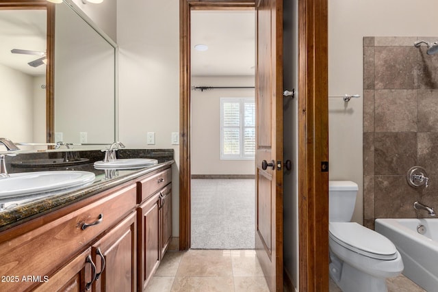 full bathroom with ceiling fan, tiled shower / bath combo, vanity, tile patterned floors, and toilet