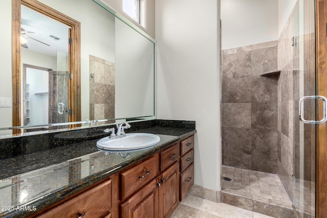 bathroom with vanity, a shower with shower door, and ceiling fan