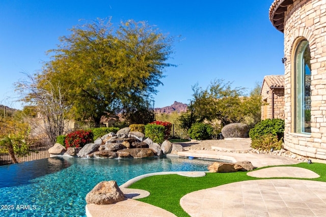 view of swimming pool with a patio and pool water feature