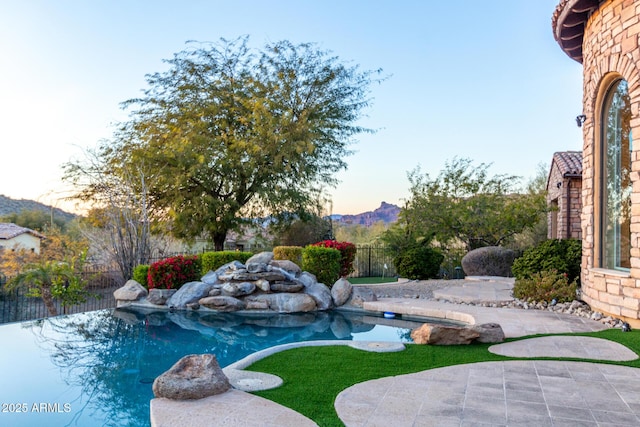 pool at dusk with a patio