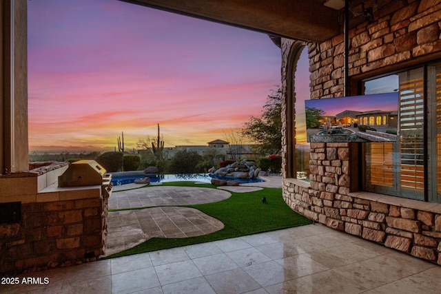 patio terrace at dusk with exterior kitchen