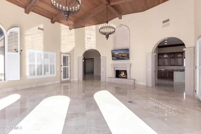 living room featuring beam ceiling, wood ceiling, and a chandelier