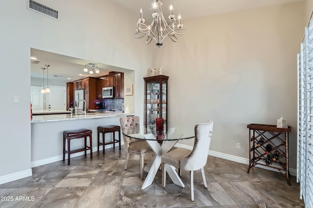 dining space with a notable chandelier and sink