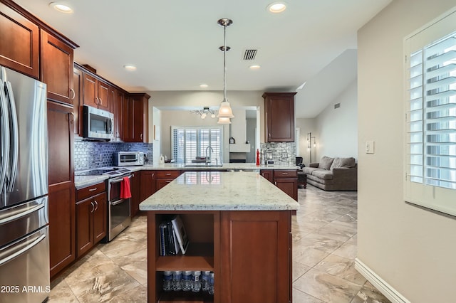 kitchen featuring a kitchen island, pendant lighting, light stone counters, kitchen peninsula, and stainless steel appliances