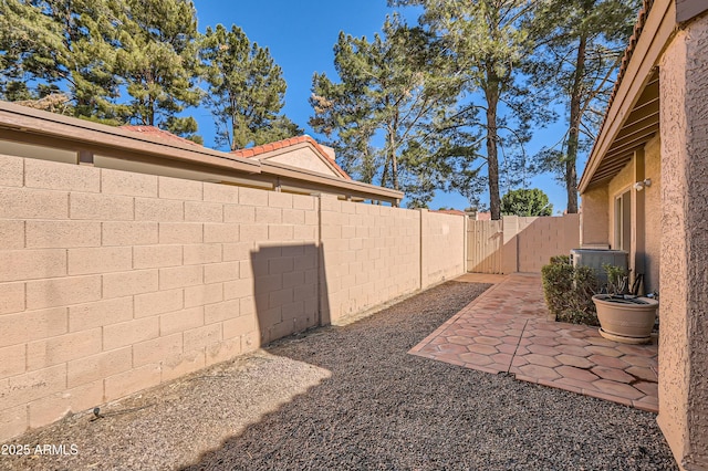 view of yard with cooling unit and a patio area